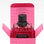 Flacon de parfum Valentino dans sa boite rose, motif diamant et etiquette noire, sur fond clair.