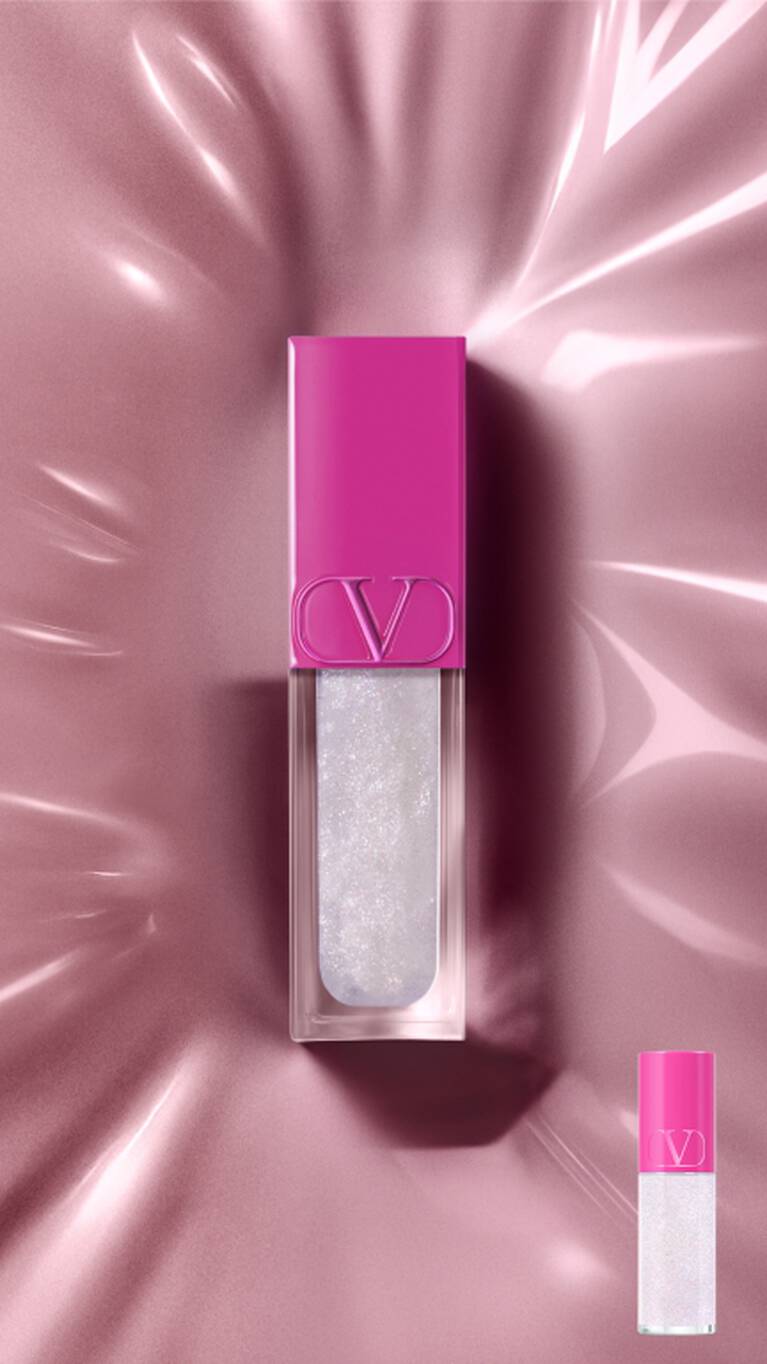 Un brillant a levres Valentino rose fuchsia et blanc scintillant sur une surface rose reflechissante. Une version plus petite est en bas a droite.